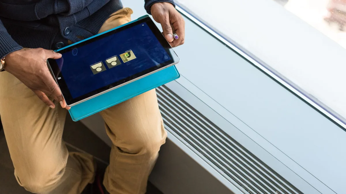 Un dirigeant manipule une tablette dans son bureau pour suivre la réalisation d'une application à Albi.