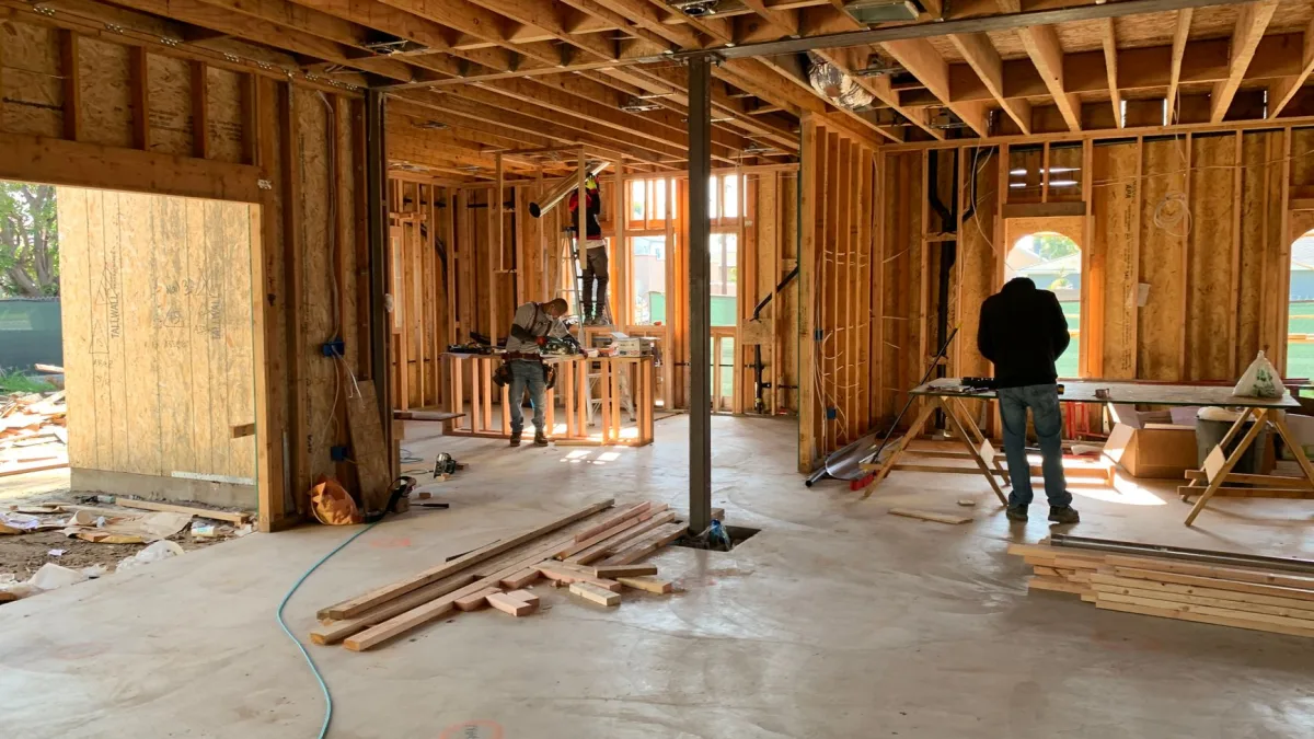 Des ouvriers s'activent sur le chantier de construction en bois d'une maison individuelle, un environnement idéal pour utiliser une application de suivi de chantier à Perpignan.