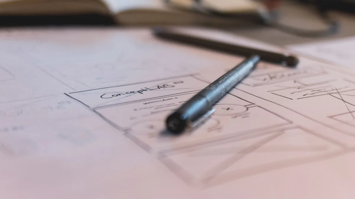 Une maquette fonctionnelle esquissée sur papier avec un stylo posé dessus illustre la réflexion sur le prix d'un site web dans le Tarn.