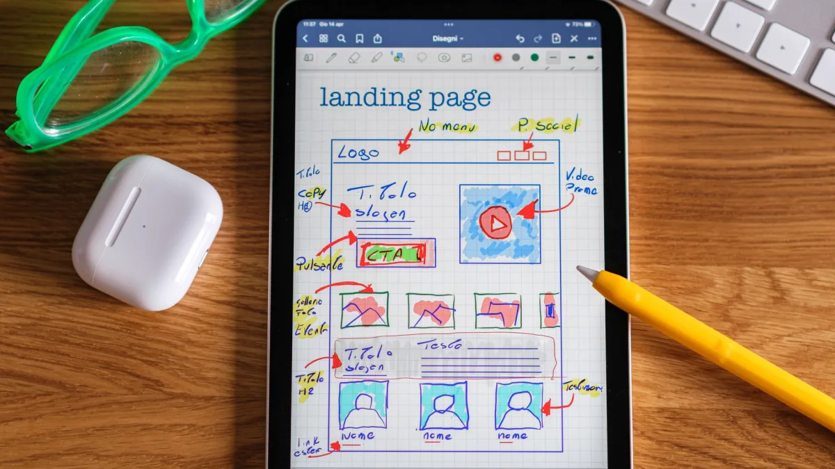 Une tablette posée sur un bureau affiche le croquis coloré d'une maquette de page web, un outil souvent utilisé par un codeur web à Albi.